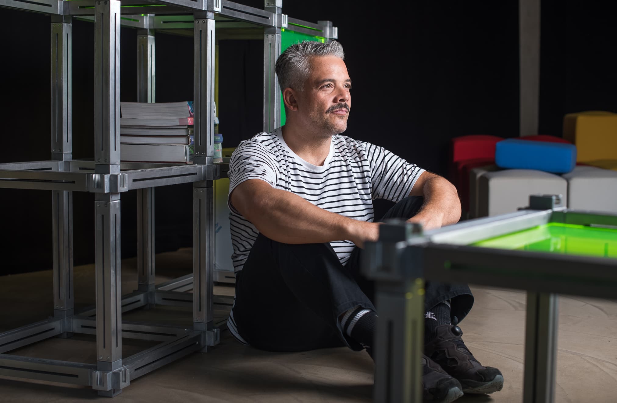 Giovanni Bruni sentado en el suelo entre estructuras modulares de Keigio