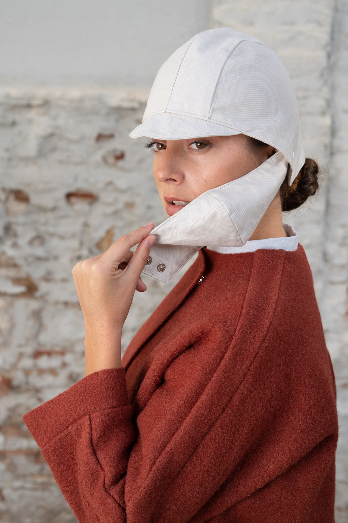Close-up of the model in a white hat and burgundy jumper