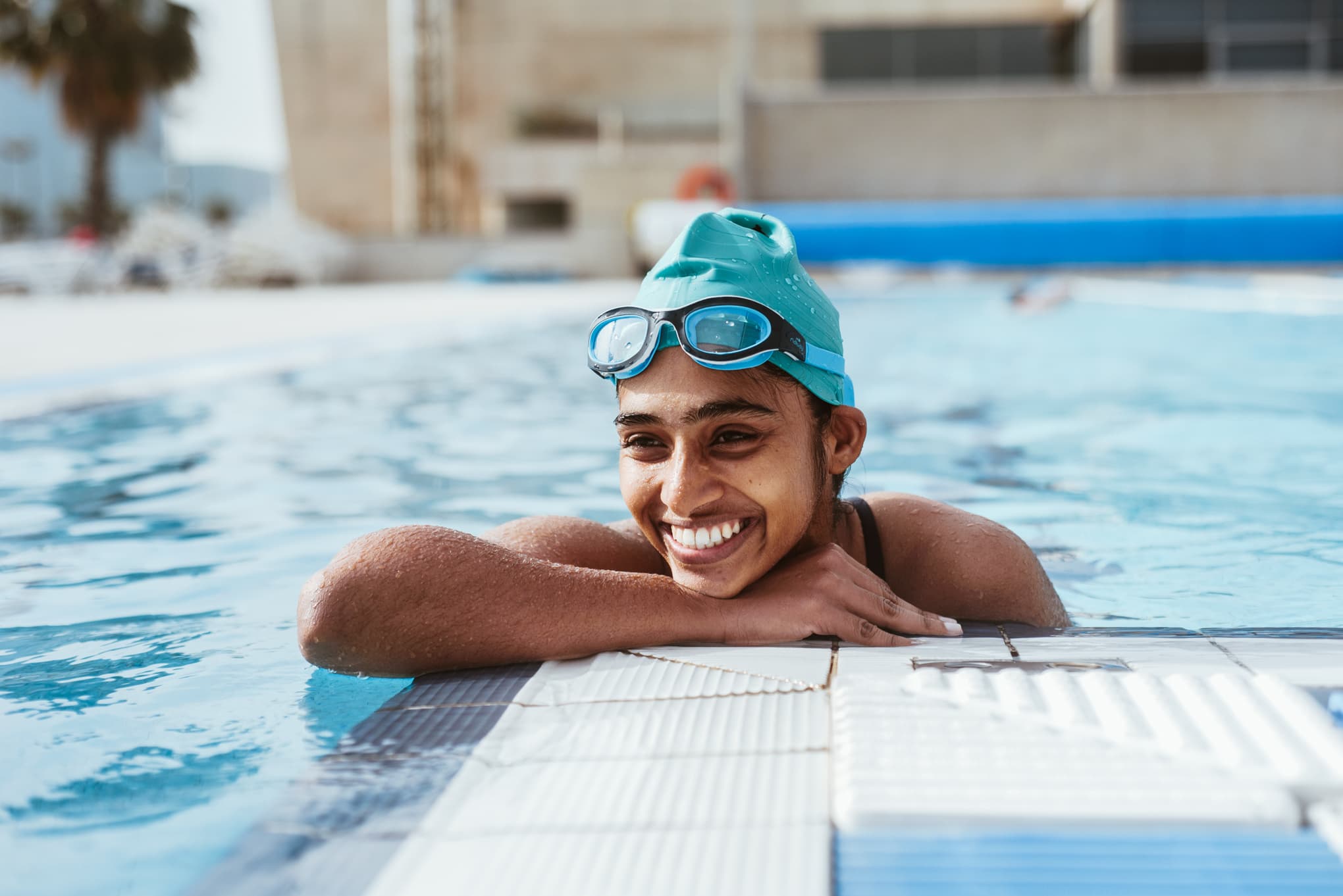 Nadadora apoyada en el borde de una piscina exterior