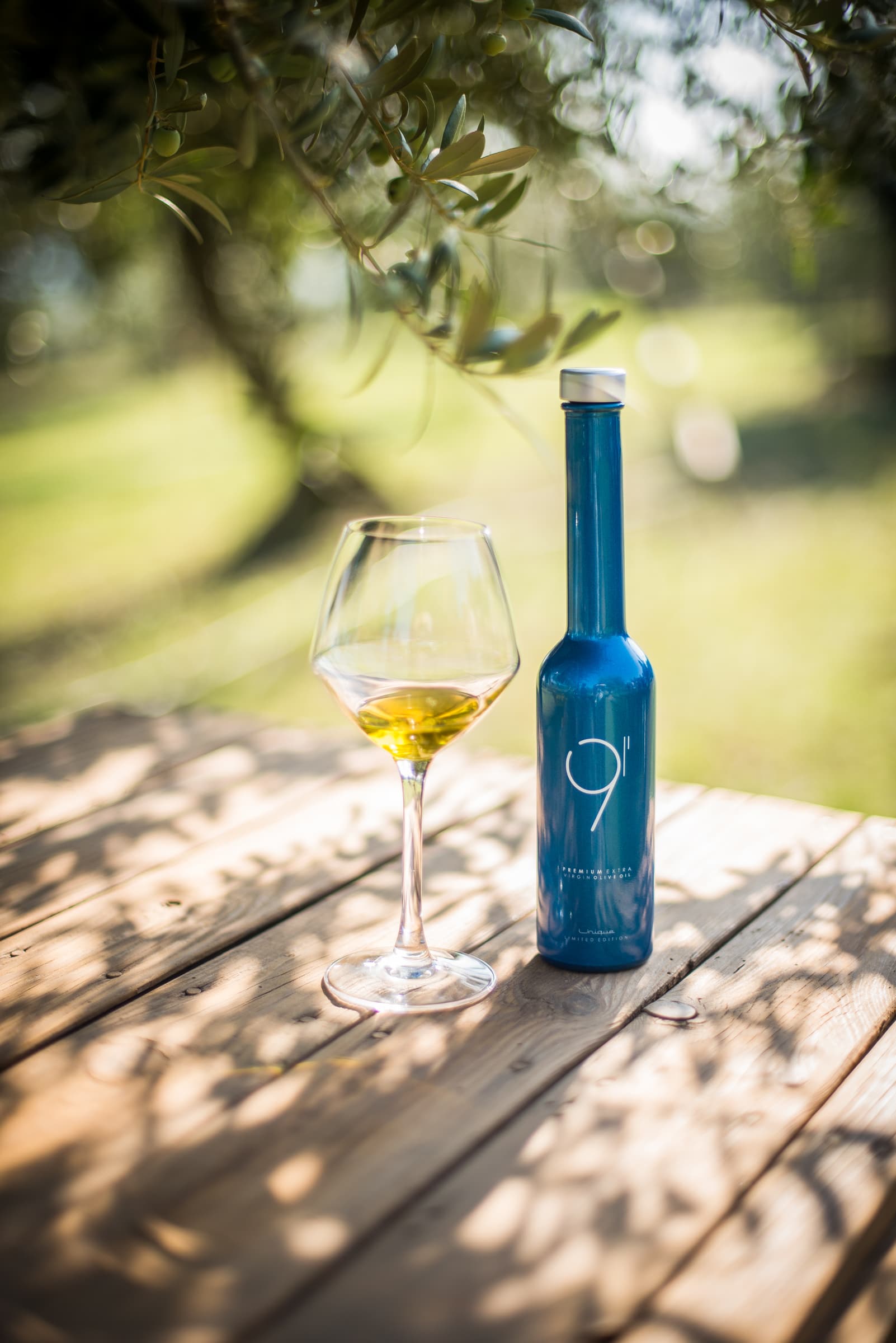 Botella y copa de vino fotografiadas en un evento al aire libre