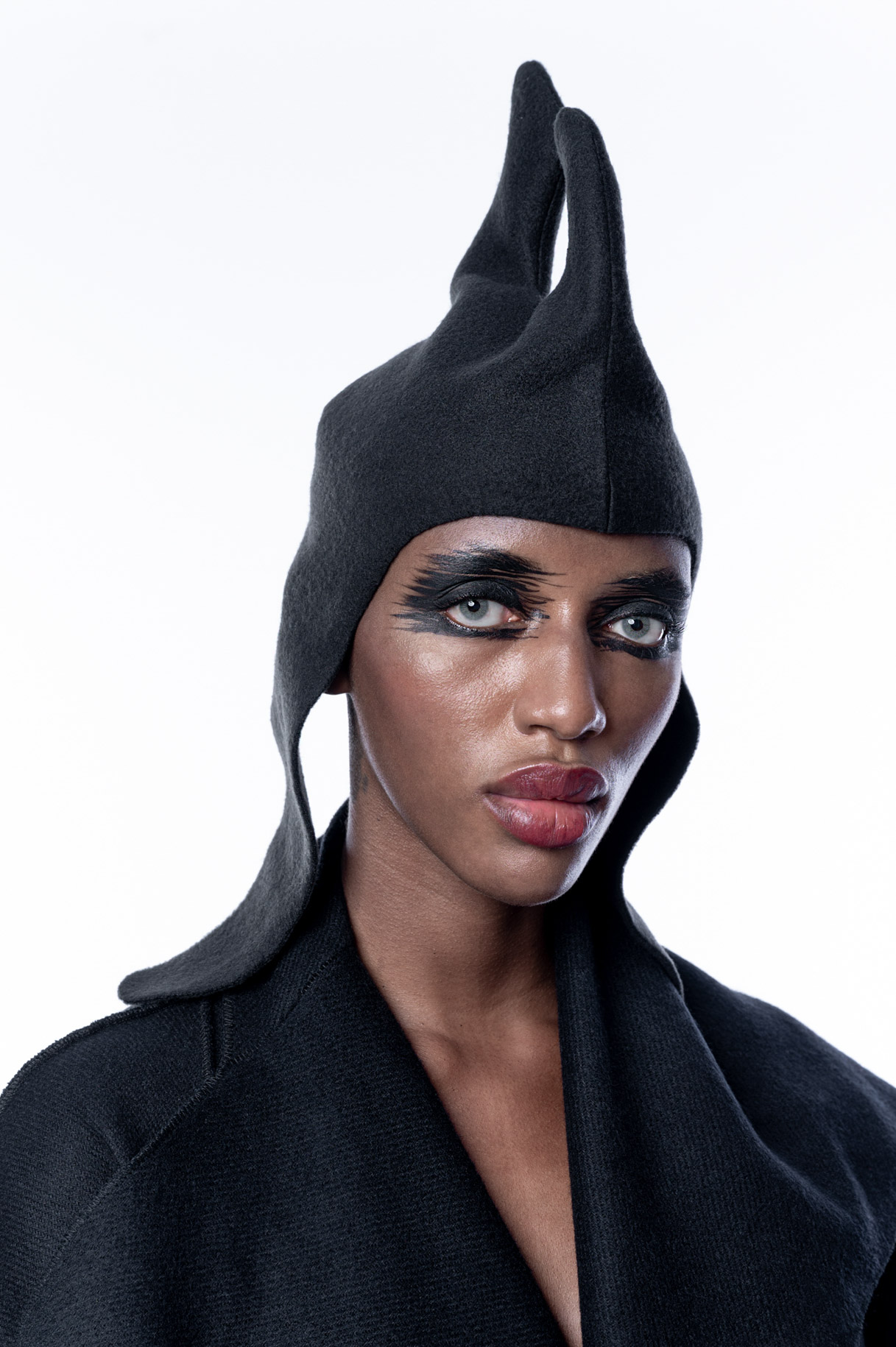 Portrait of a model in a black spiked headpiece and dark coat